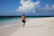 Happy man walking along the beach with a relaxed, confident smile.
