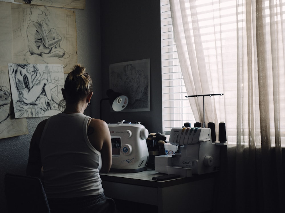 a woman sitting at a desk in front of a window