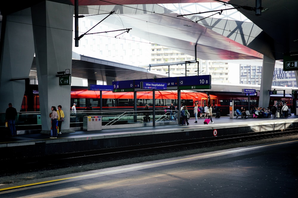 a train station with people waiting for the train