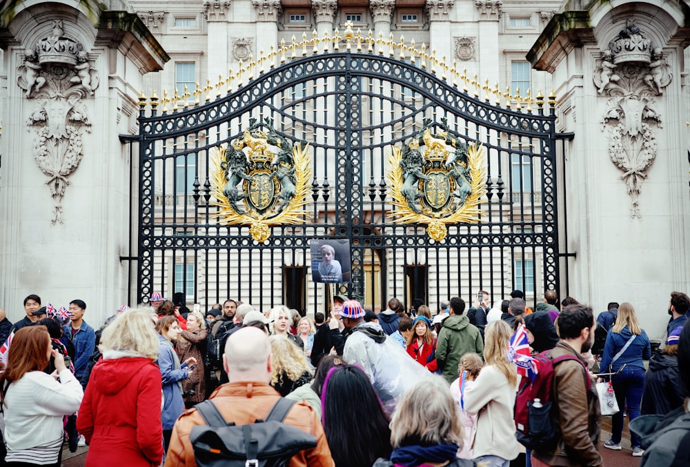 a crowd of people standing in front of a gate