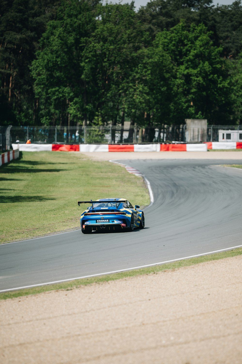 Un'auto da corsa blu che guida lungo una pista da corsa