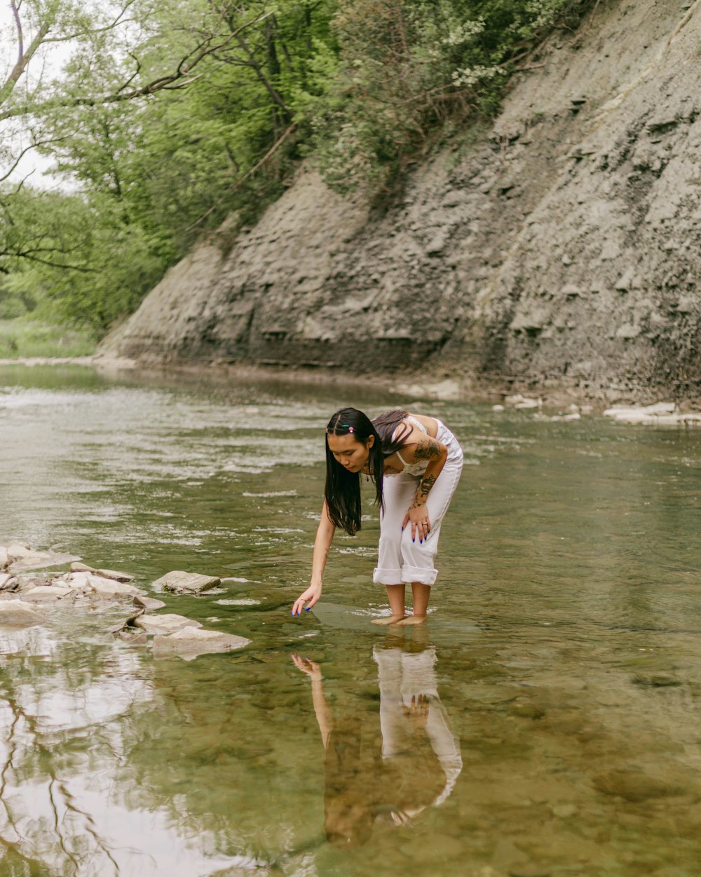 a woman standing on a rock in a river