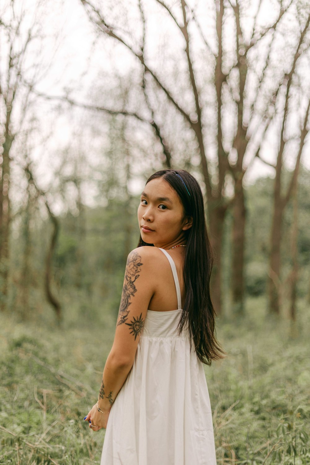 a woman in a white dress standing in a field