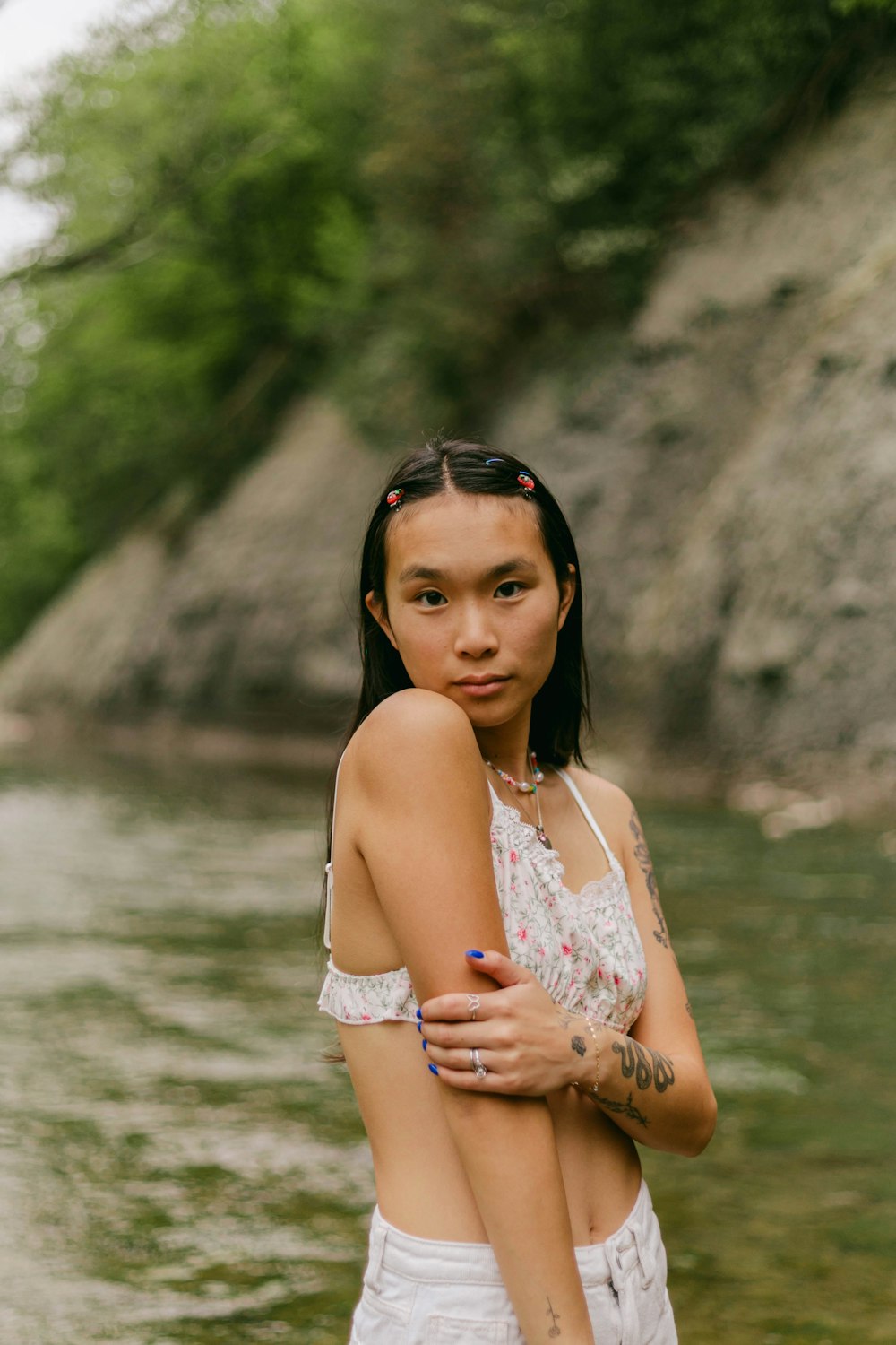 a woman standing next to a body of water