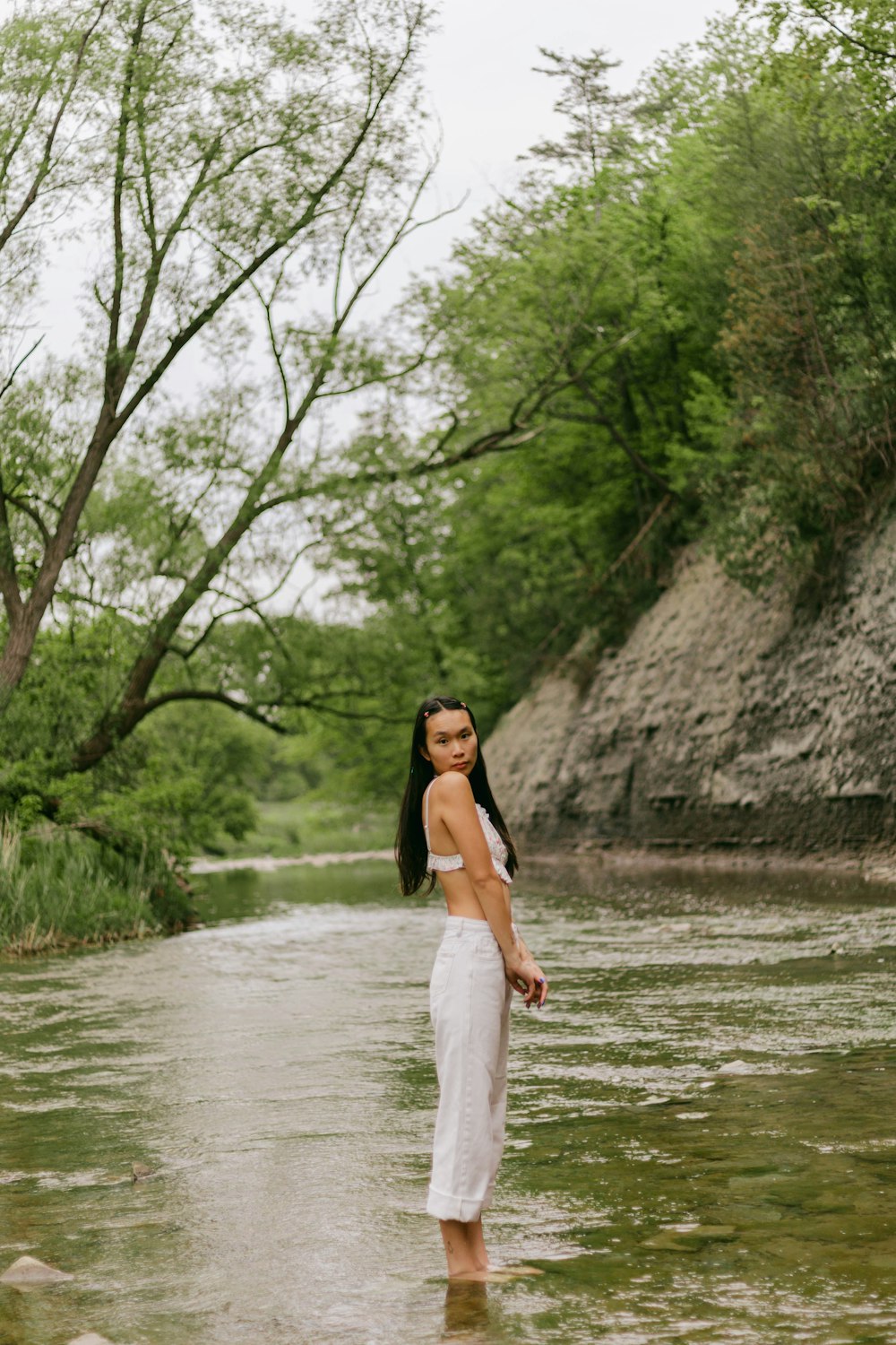 a woman standing in the middle of a river