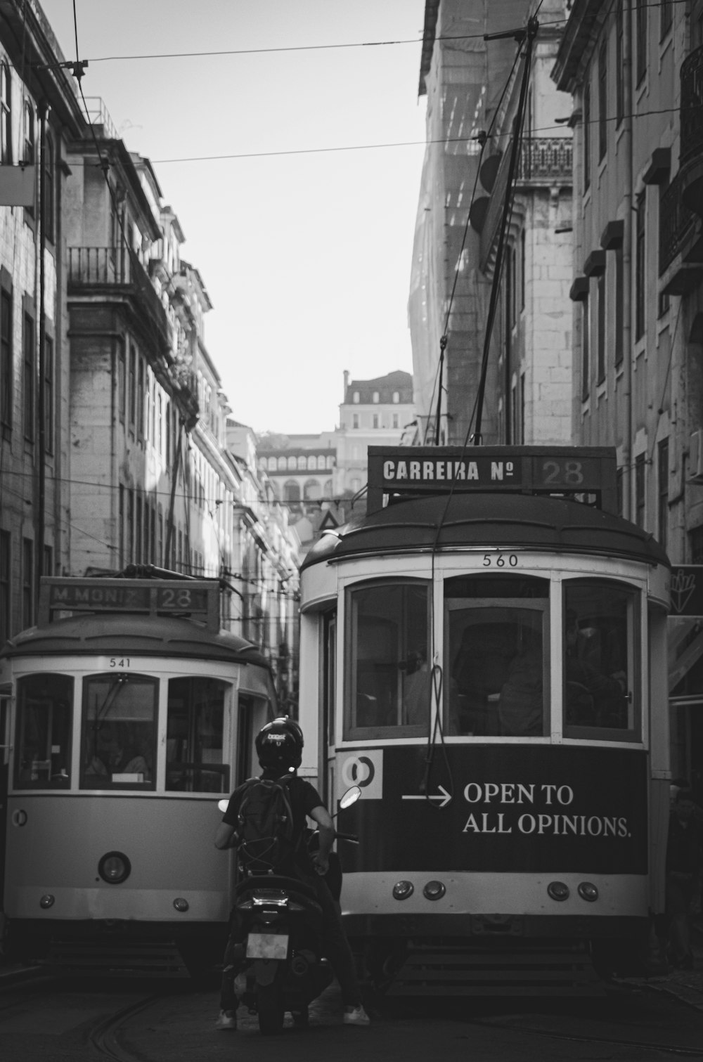 a black and white photo of two trolleys on a street