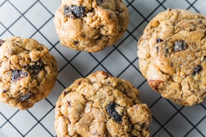 Warm oatmeal raisin cookies cooling on a wire rack with a soft kitchen towel