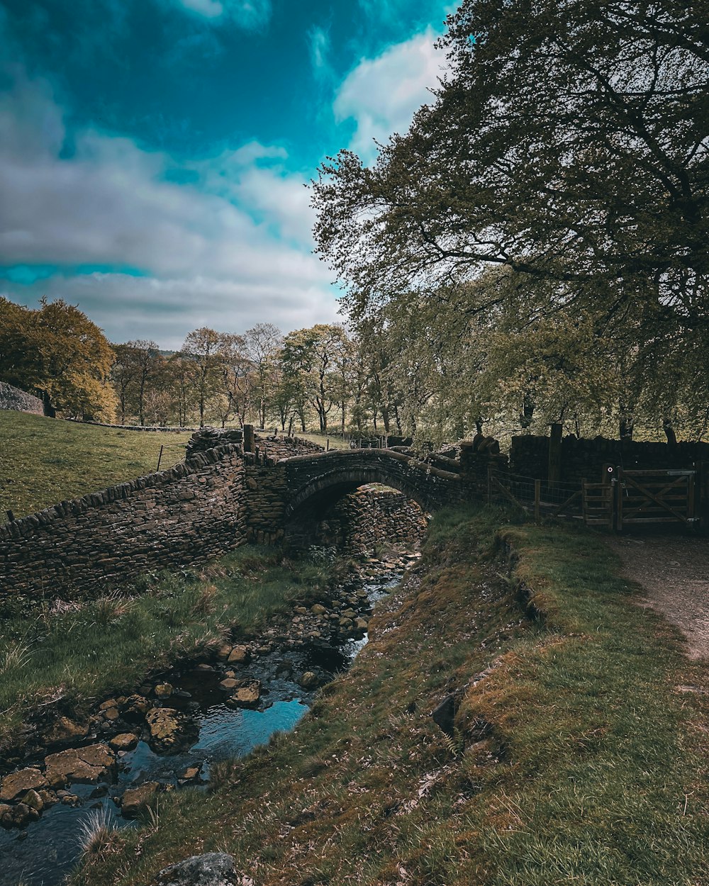 a small bridge over a small stream in a field