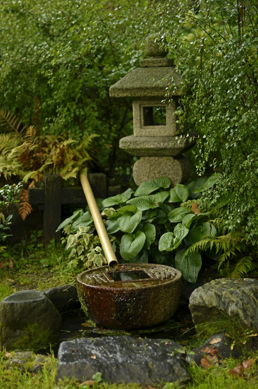 a garden with a stone lantern and a potted plant