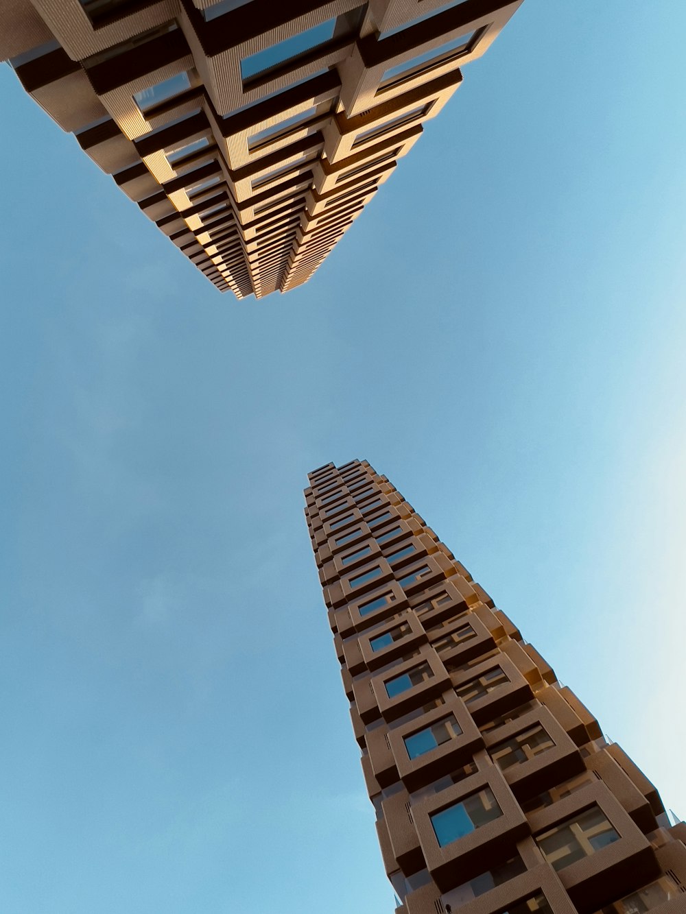 looking up at two tall buildings in a city