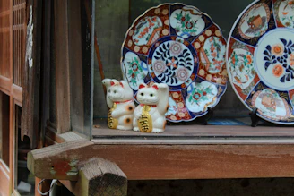 Elegant pet urns with delicate paw motifs resting on a wooden shelf.