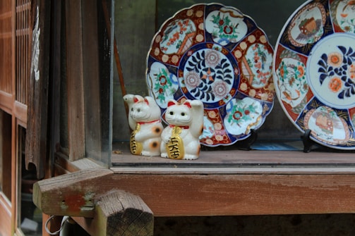 Elegant porcelain figurines displayed on a polished wooden shelf.