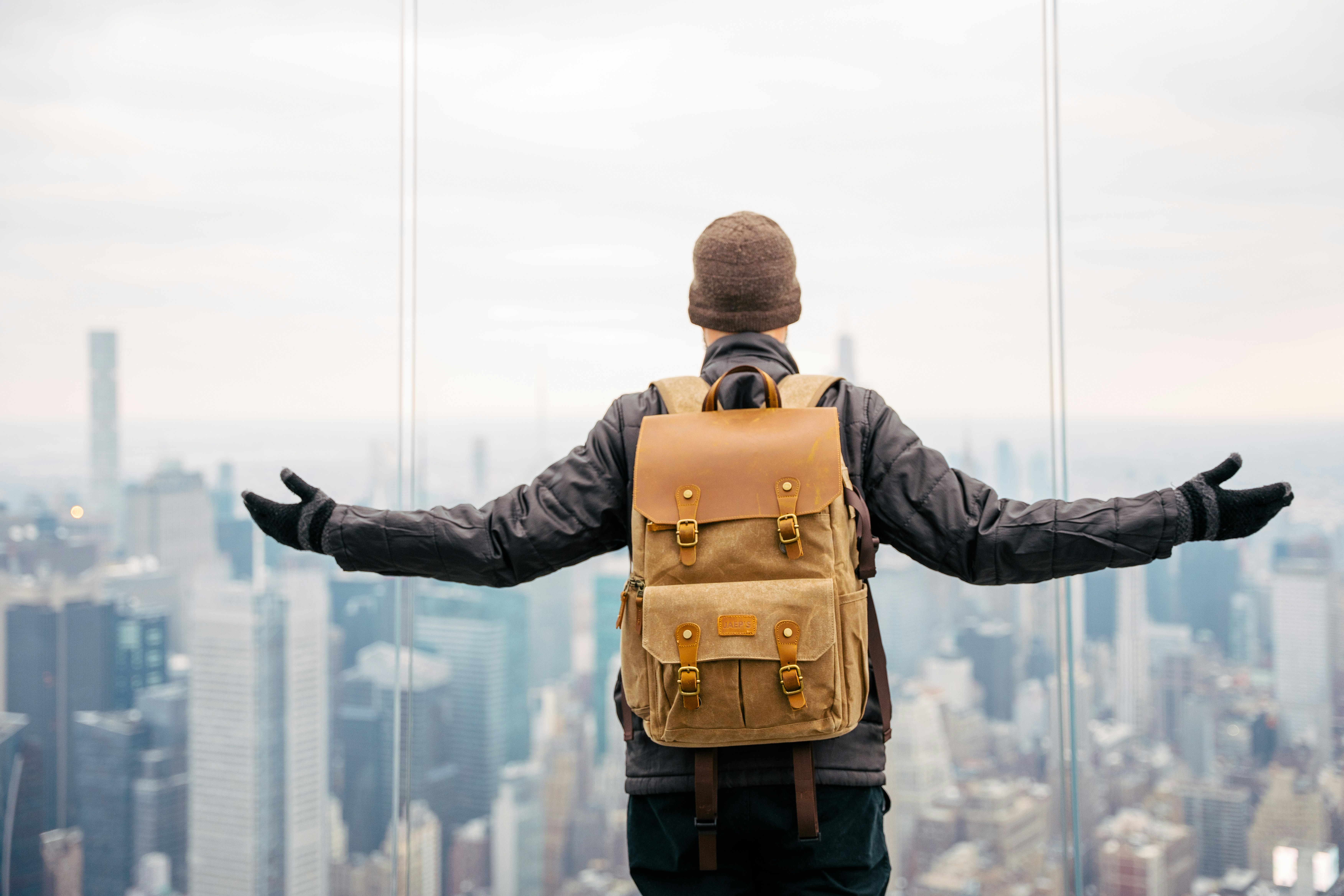 Un voyageur avec un sac à dos observant la ville depuis le toit d un immeuble
