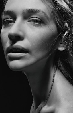 Bold editorial portrait with high contrast lighting and a strong asymmetrical composition, burnt orange tones highlighting details.