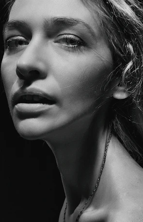 Monochrome portrait of a person in natural light, emphasizing texture and emotion.