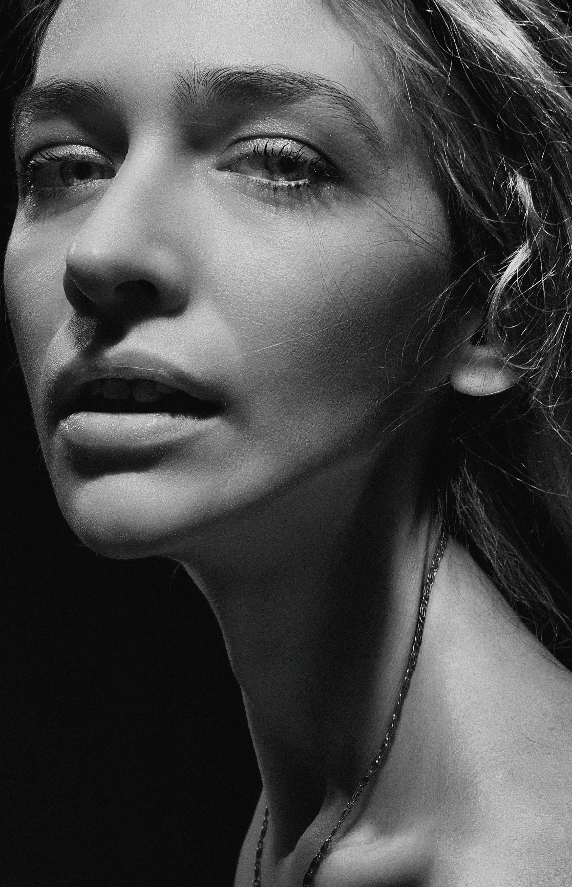 A minimalist portrait with stark contrast, highlighting the subject's expressive eyes in monochrome.