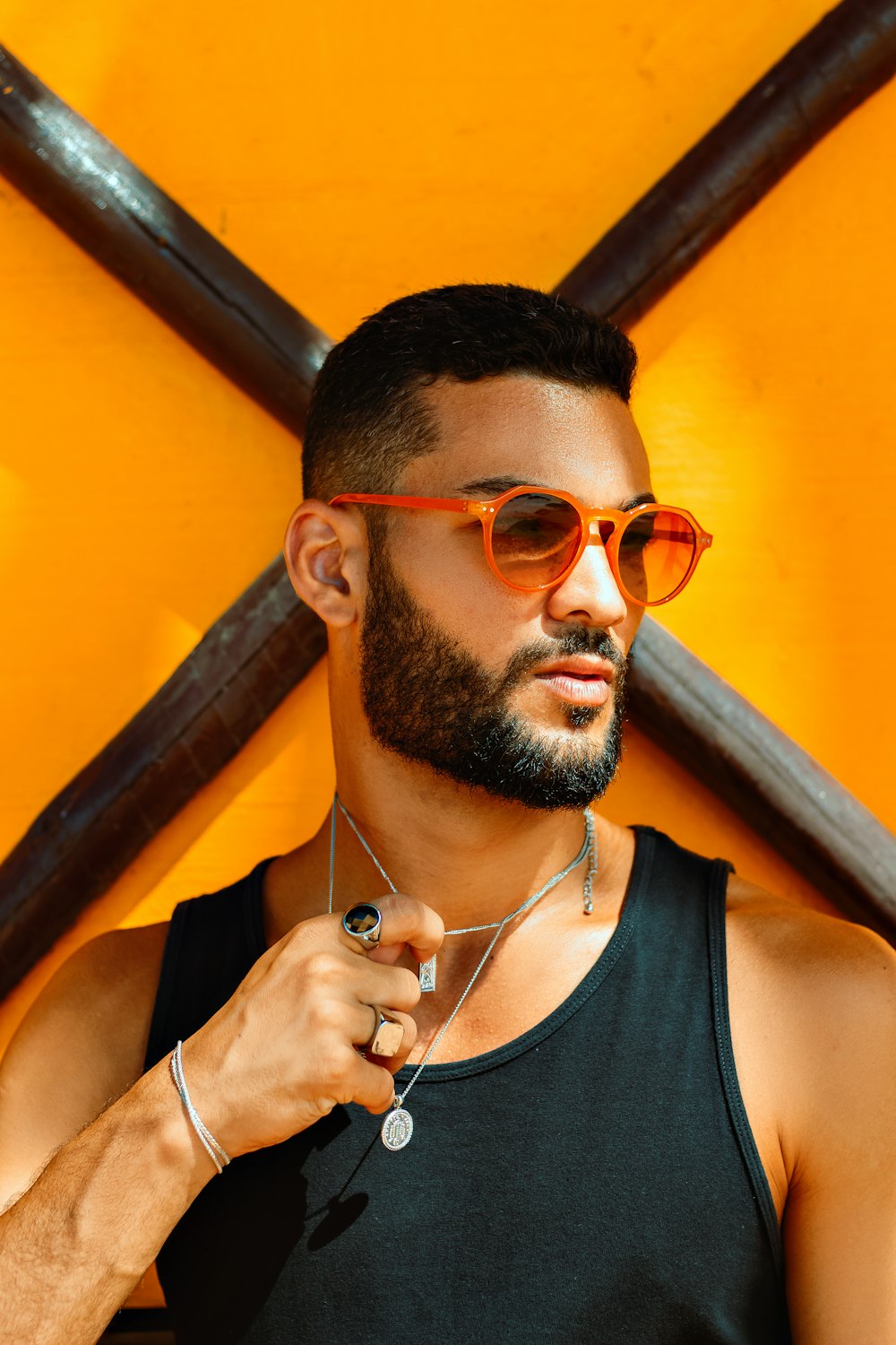a man with a beard wearing sunglasses and a necklace
