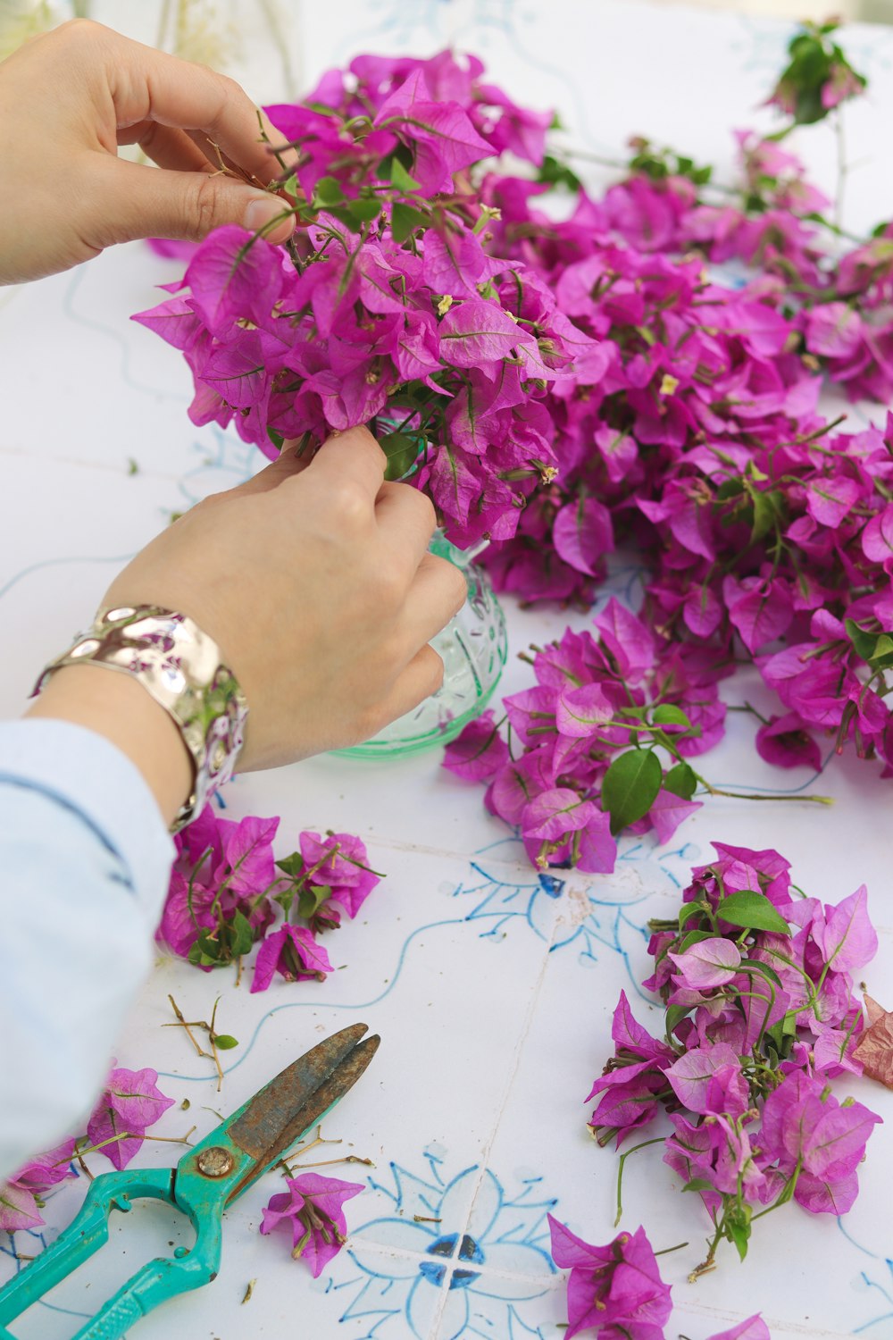 a person cutting flowers with scissors on a table