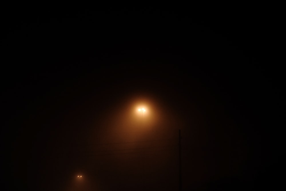 a foggy night with a street light in the distance