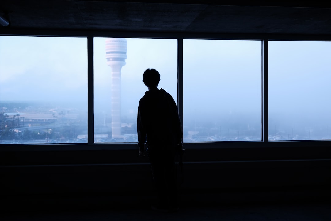 a man standing in front of a large window,