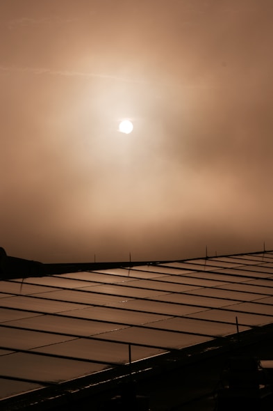the sun is shining through the clouds over a building