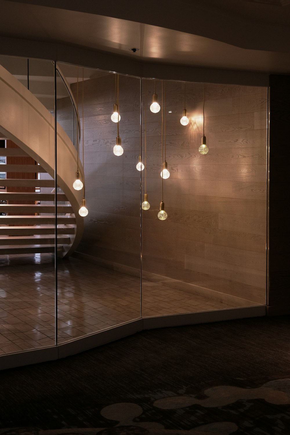 a room with a spiral staircase and lights hanging from the ceiling