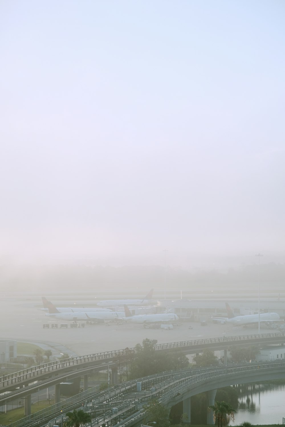 a foggy day at an airport with planes on the tarmac