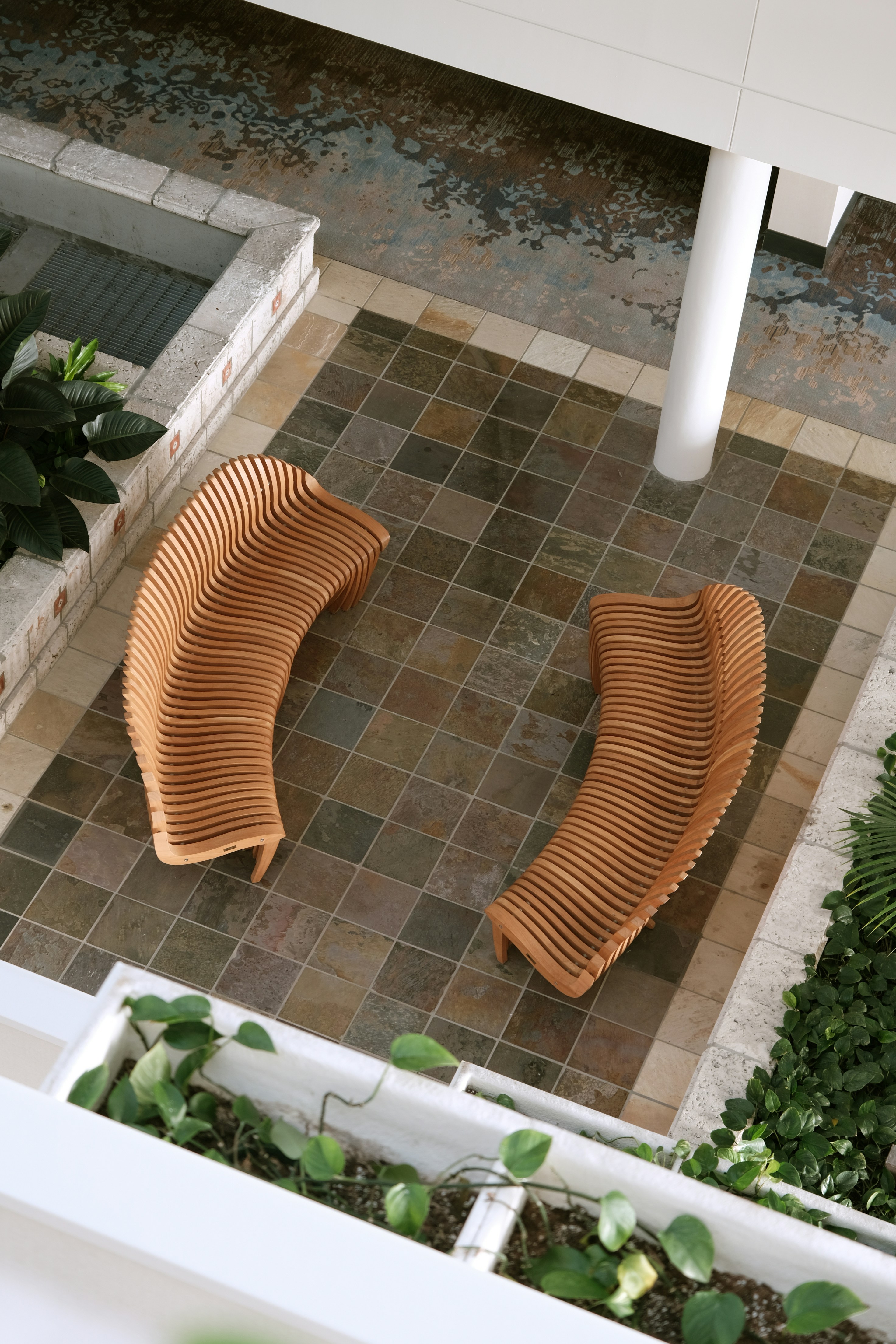 a couple of wooden benches sitting on top of a tiled floor