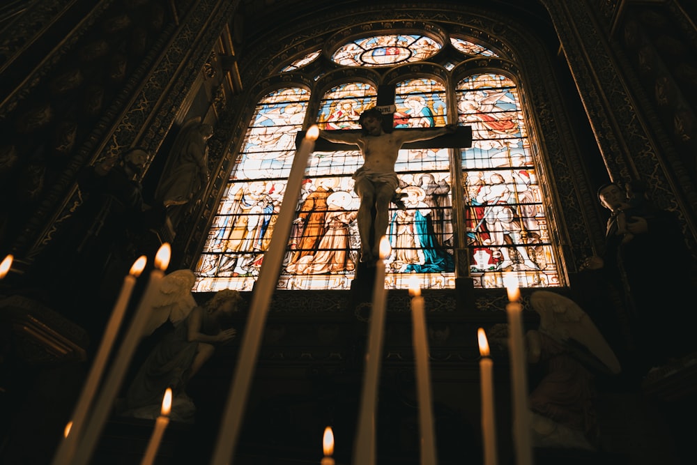 a crucifix in front of a stained glass window