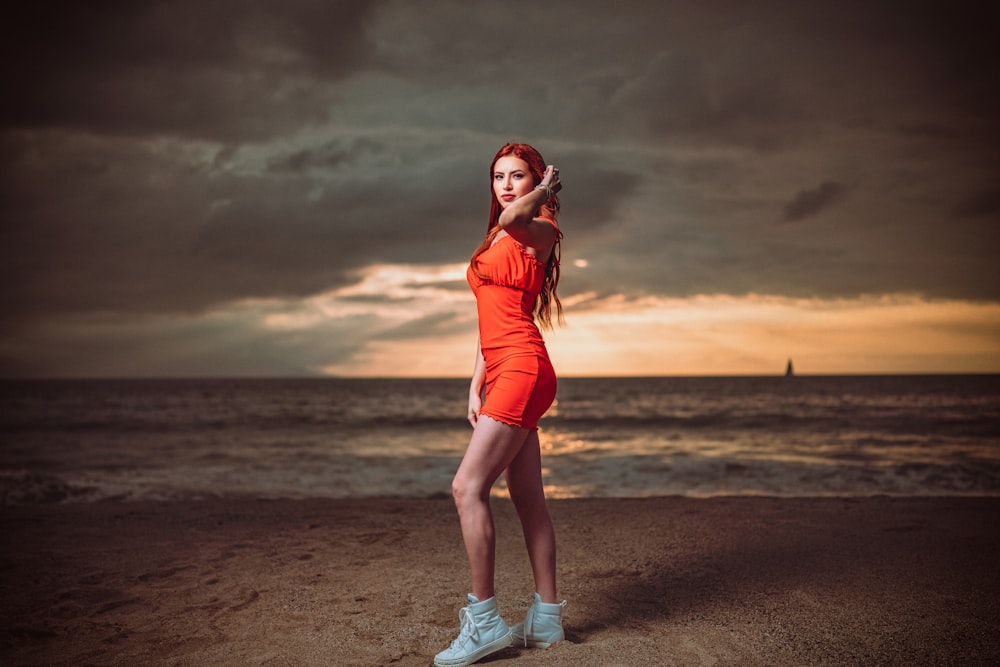 a woman in an orange dress on the beach