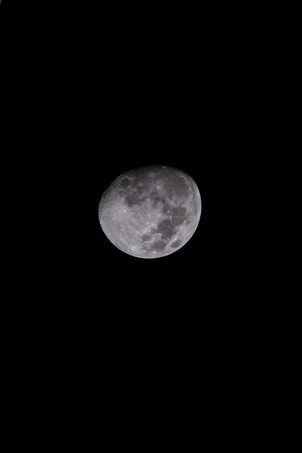 a full moon is seen in the dark sky