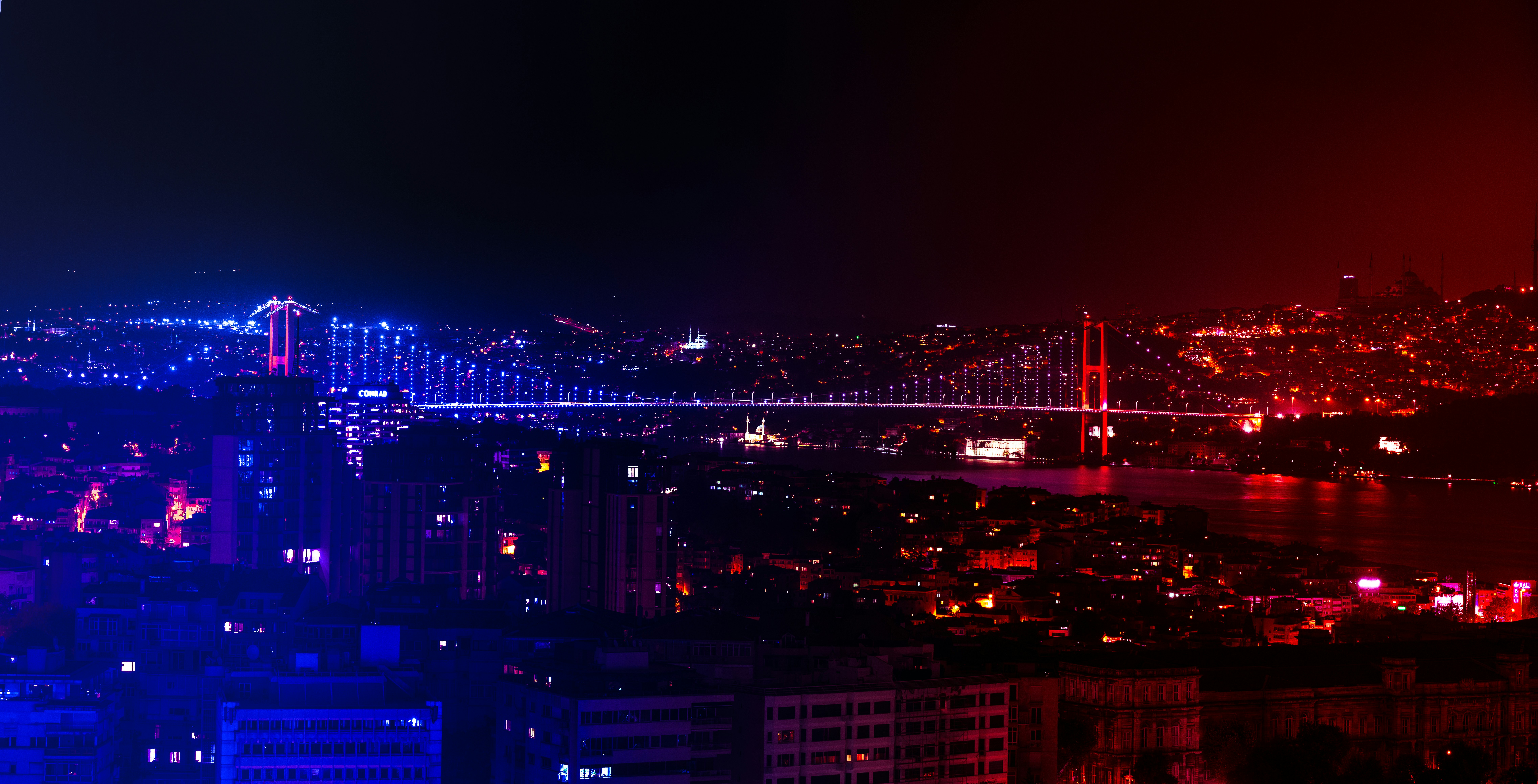 Una vista notturna di una città con un ponte sullo sfondo