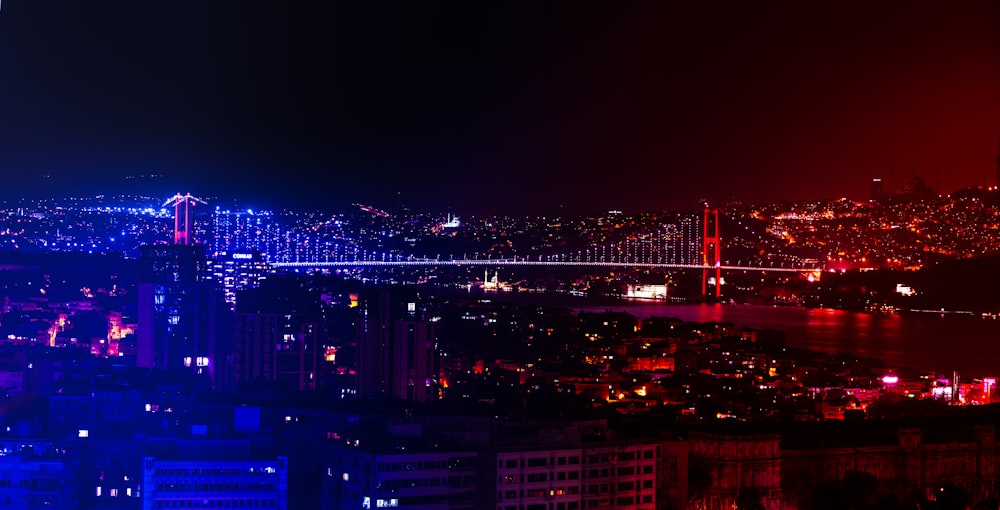 a night view of a city with a bridge in the background