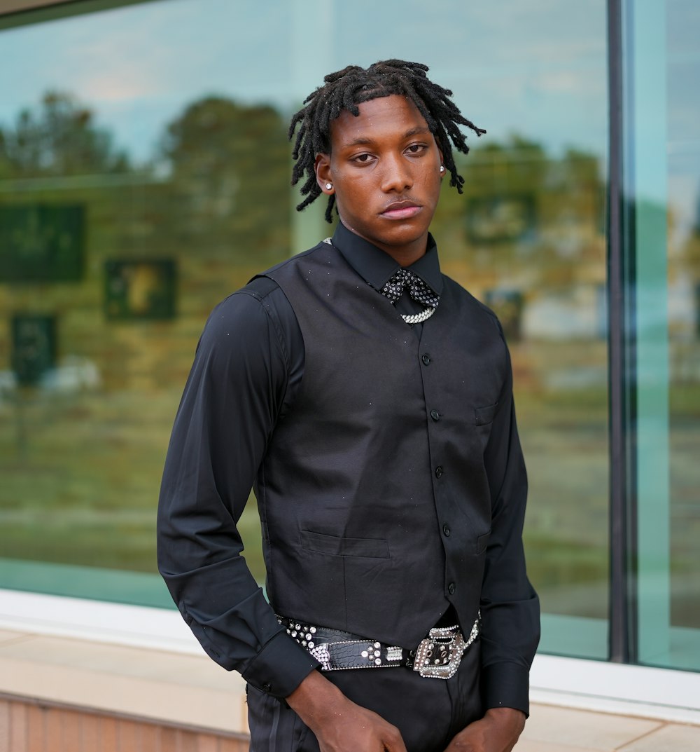 a man with dreadlocks standing in front of a window