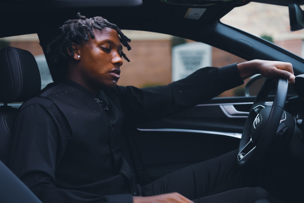 a man with dreadlocks sitting in a car