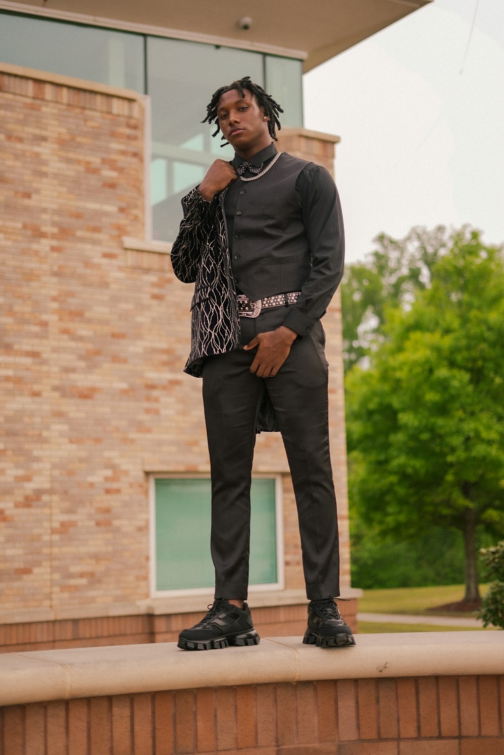 a man standing on a ledge in front of a building