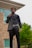 A well-dressed man wearing a stylish autumn jacket, standing confidently in an urban setting.