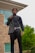 A well-dressed man wearing a stylish autumn jacket, standing confidently in an urban setting.