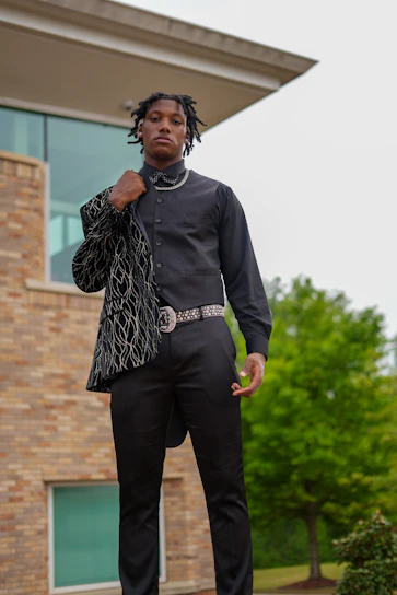 A model confidently wearing a sleek, modern jacket from the new collection, standing against a minimalist urban backdrop.