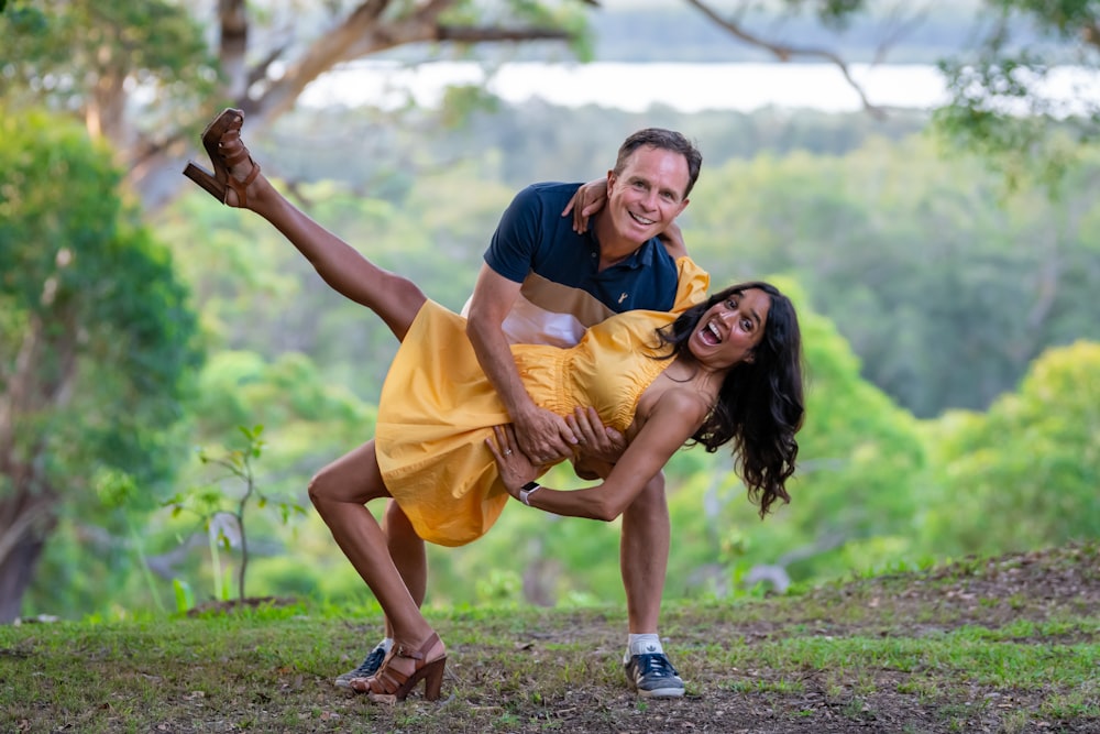 a man holding a woman in a yellow dress