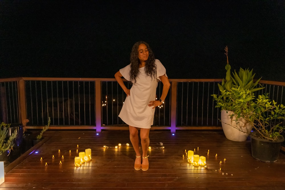 a woman standing on a deck surrounded by candles