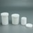 A set of three white, cylindrical containers with removable lids is displayed against a plain grey background. The containers vary in size, arranged from largest on the left to smallest on the right. The smallest container has its lid placed beside it.