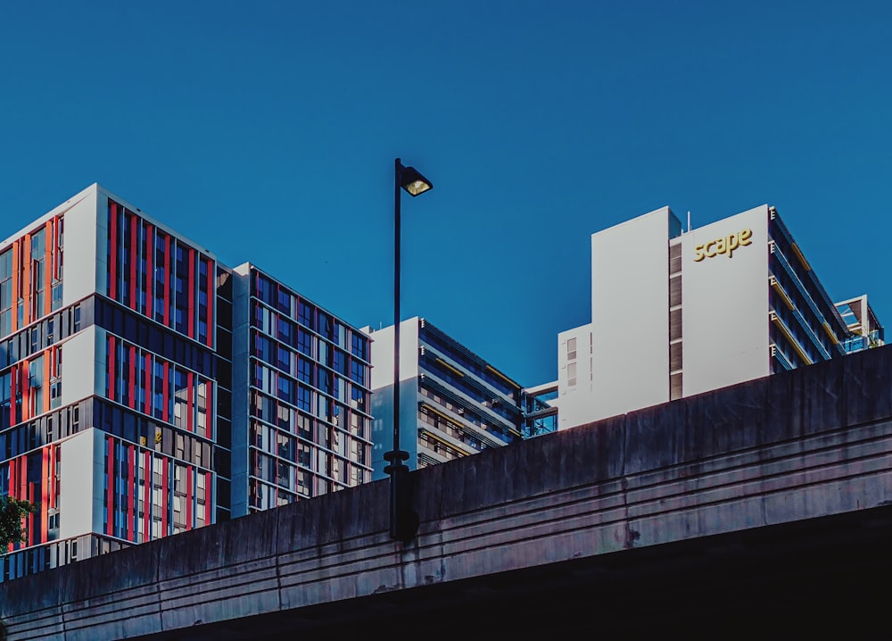 a street light on top of a bridge next to tall buildings