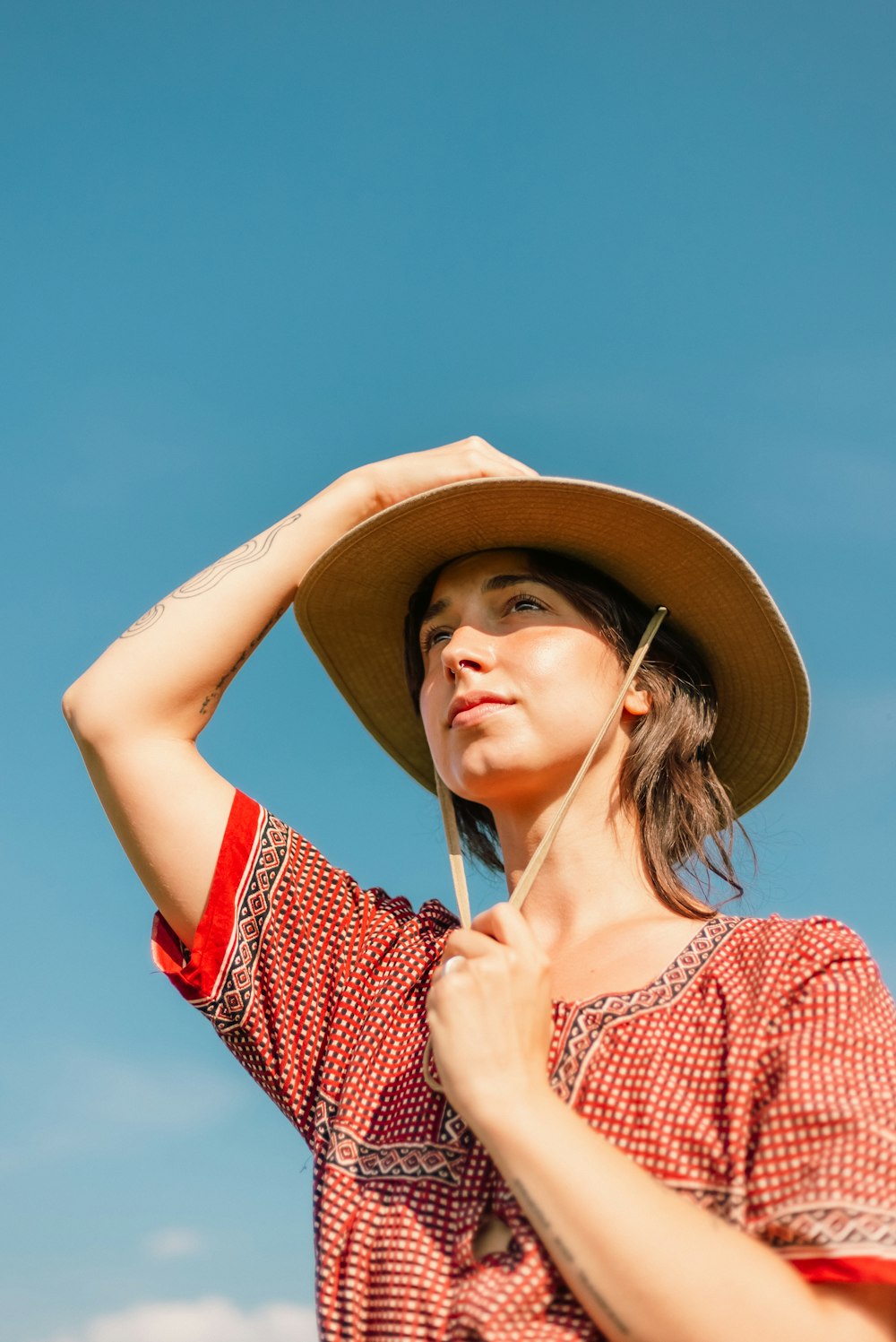 una donna che indossa un cappello e tiene un ombrello