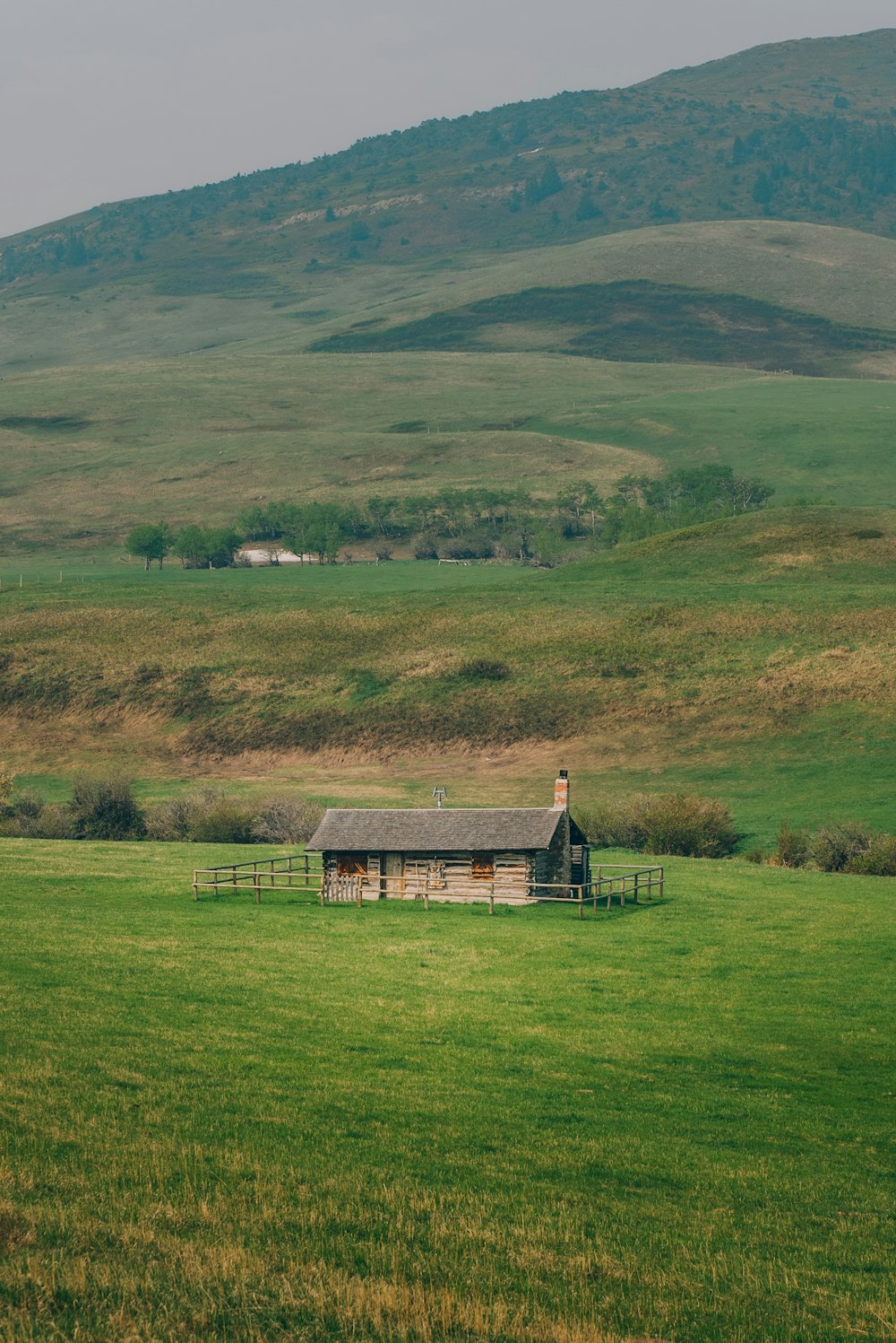 Una casa in un campo con una montagna sullo sfondo