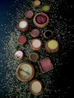 Close-up of traditional Indian herbal powders arranged in earthen bowls on a rustic cloth.