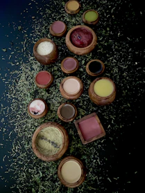 A collection of colorful spell ingredients and herbs arranged on a dark cloth.