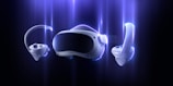 A futuristic virtual reality headset with two handheld controllers is featured against a dark background with a glowing blue aura surrounding them. The design is sleek and modern, emphasizing advanced technology.