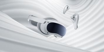 A virtual reality headset and two controllers are suspended against a backdrop of smooth, swirling white fabric, evoking a sense of fluidity and modern technology.