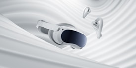 A virtual reality headset and two controllers are suspended against a backdrop of smooth, swirling white fabric, evoking a sense of fluidity and modern technology.